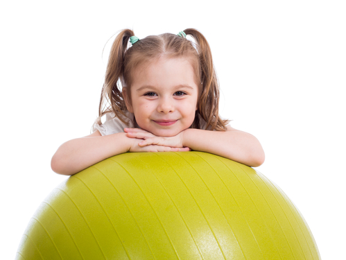 Child girl having fun with  gymnastic ball isolated
